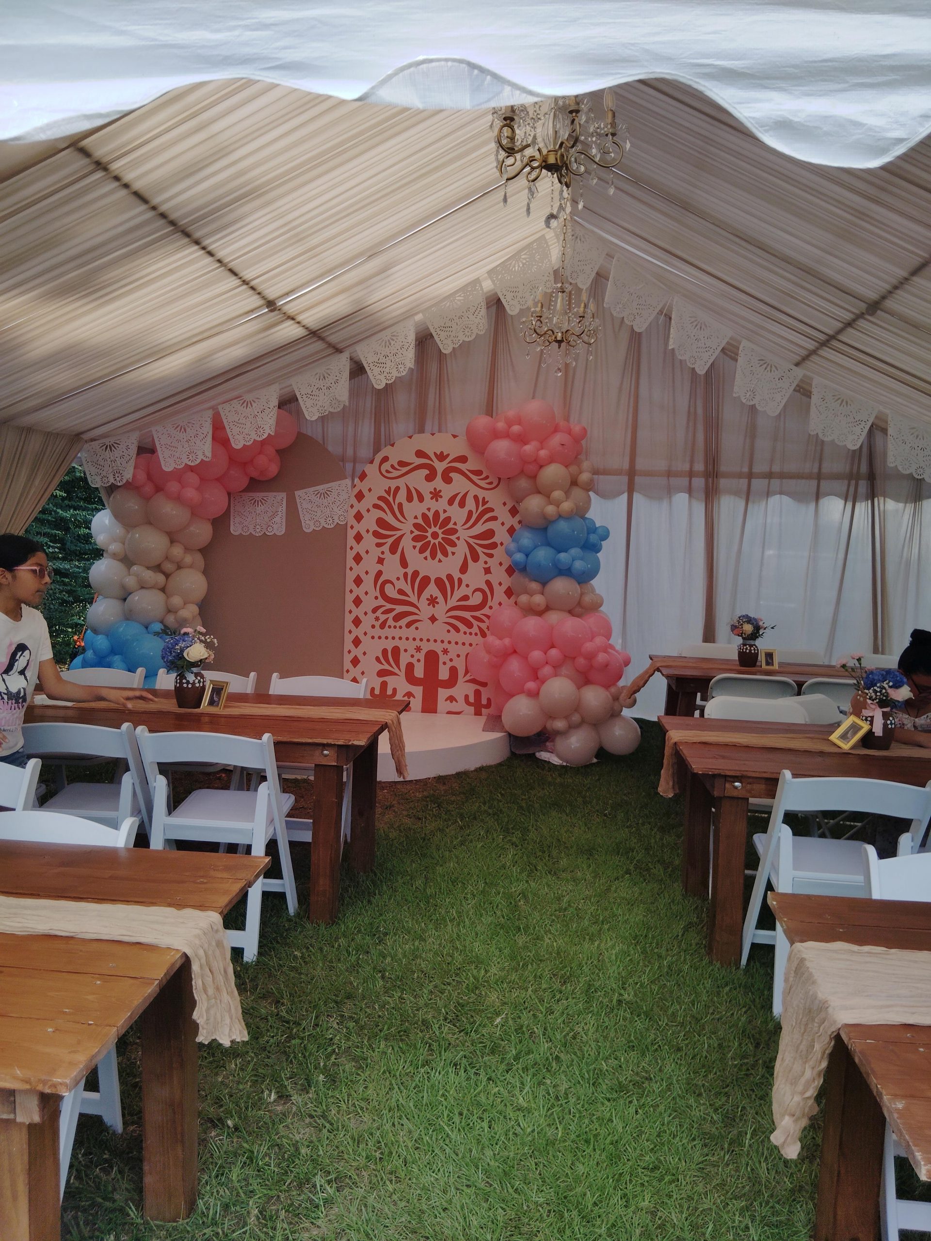 Neutral tent draping with chandeliers and event tables