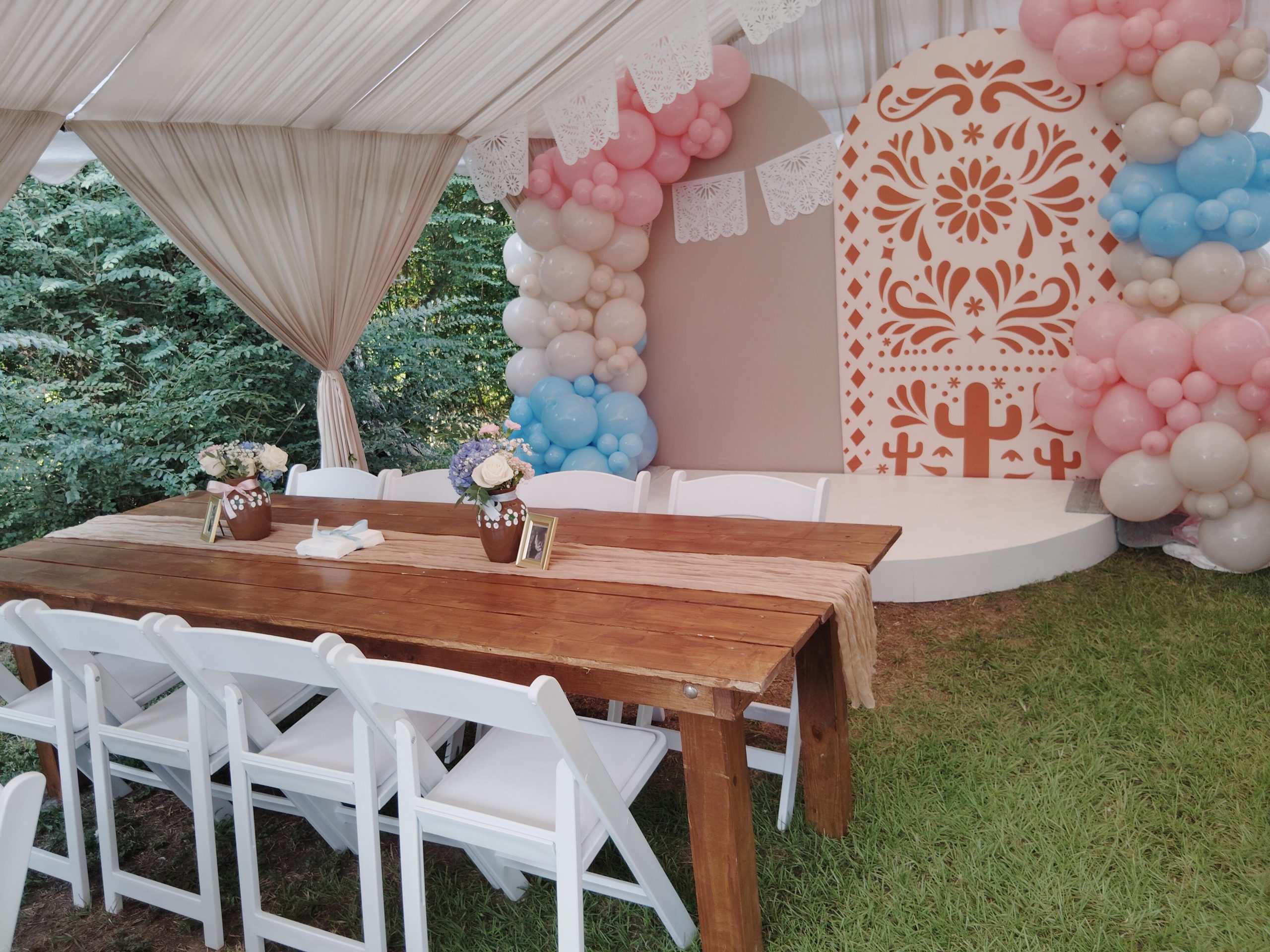 Event tables and white chairs inside a draped tent