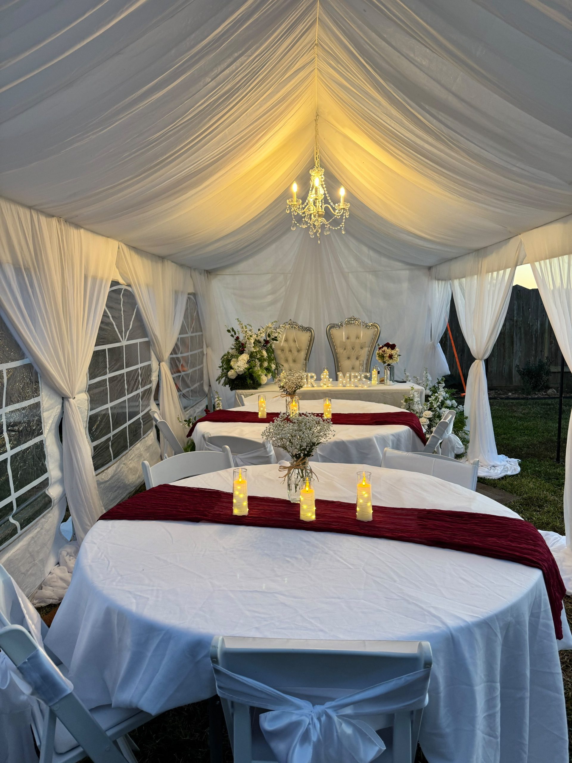 Chandelier lighting inside a draped event tent